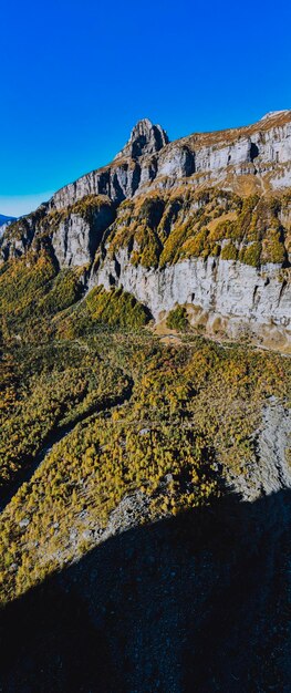 Low angle view of rocky mountains against clear blue sky