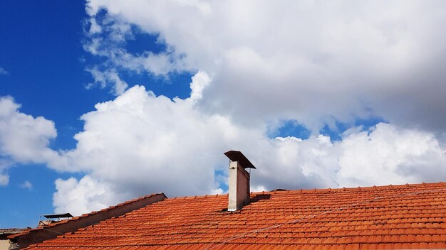 Low angle view of roof of building against cloudy sky