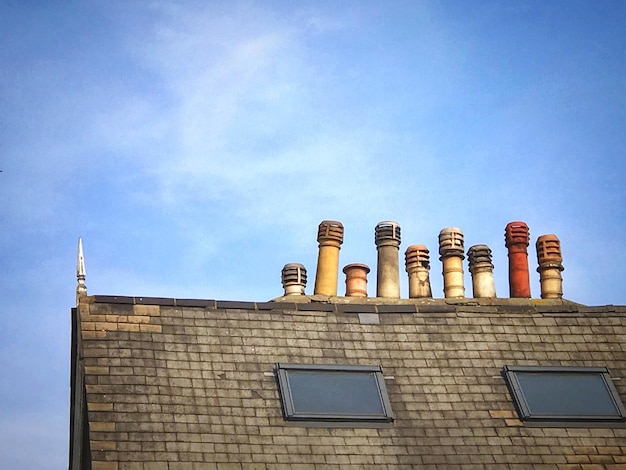 Photo low angle view of roof with chimneys against sky