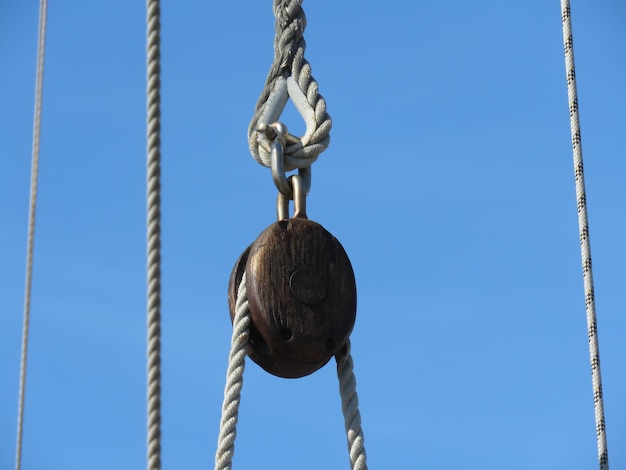 Photo low angle view of rope with pulley against clear blue sky