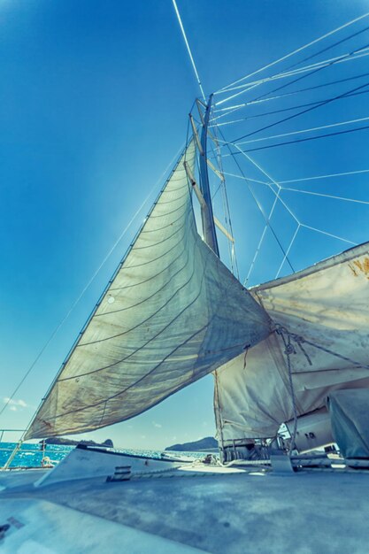 Low angle view of sailboat against blue sky