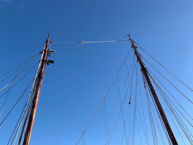 Foto vista a basso angolo di una barca a vela contro un cielo blu limpido