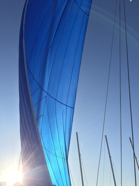 Low angle view of sailboat against clear blue sky