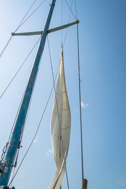 Foto vista a bassa angolazione di una barca a vela contro un cielo blu chiaro