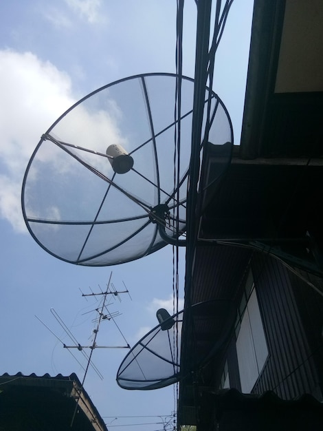 Photo low angle view of satellite dishes on building against sky