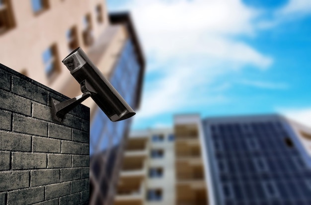 Low angle view of security camera on wall in city