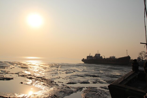 Photo low angle view of ship sailing on sea during sunset