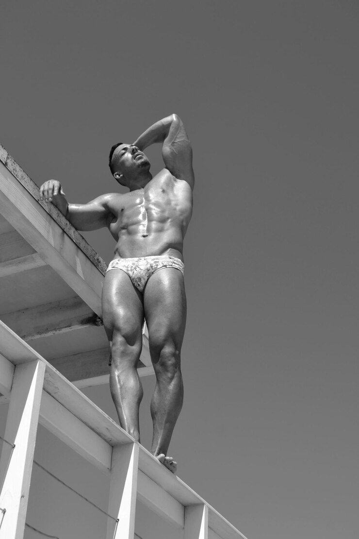 Photo low angle view of shirtless muscular man standing against clear sky
