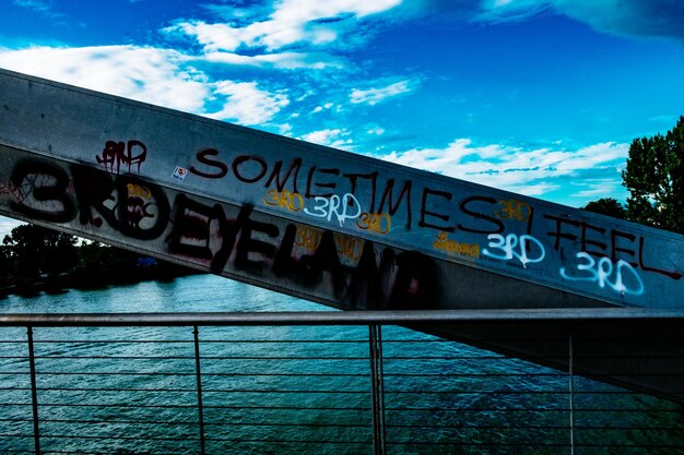 Low angle view of sign board against blue sky