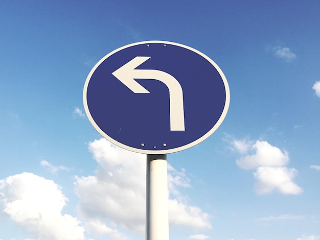 Low angle view of sign board against blue sky