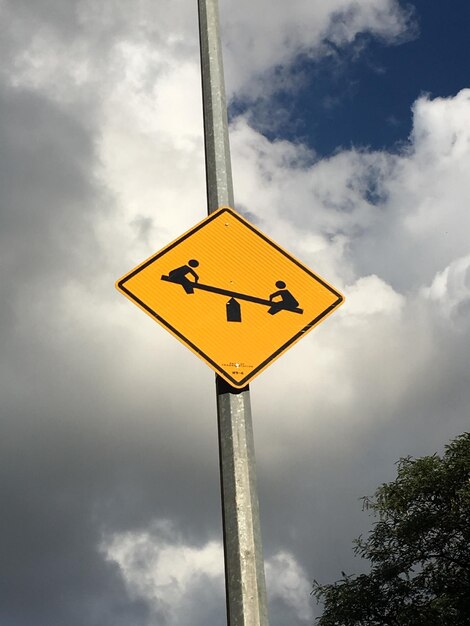 Low angle view of sign board against sky