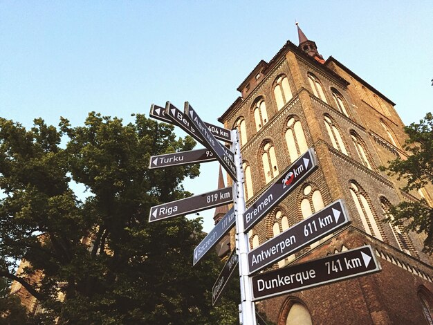 Photo low angle view of sign board and building against clear sky