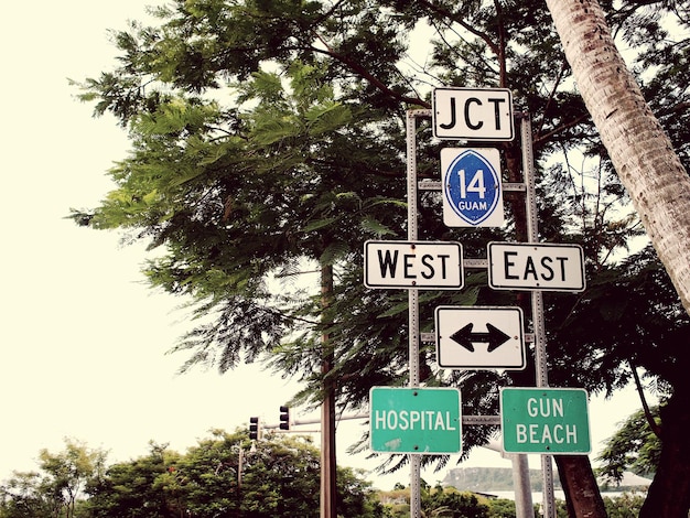 Photo low angle view of signboards against trees