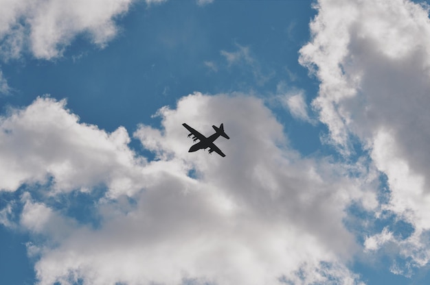 雲の空に照らして飛ぶシルエット飛行機の低角度の景色