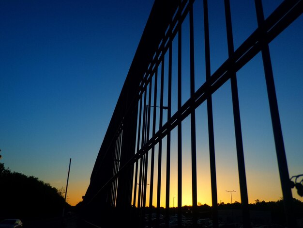 Low angle view of silhouette bridge against clear sky