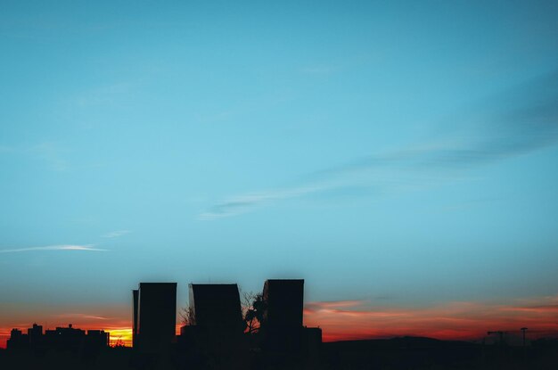 Low angle view of silhouette buildings against sky at sunset