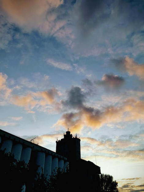 Low angle view of silhouette buildings against sky