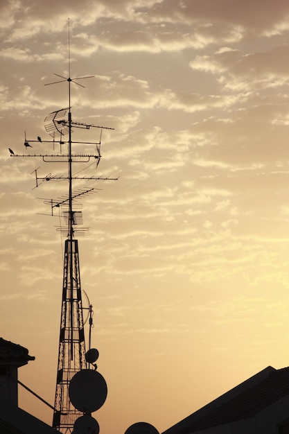 Photo low angle view of silhouette communications tower against sky during sunset