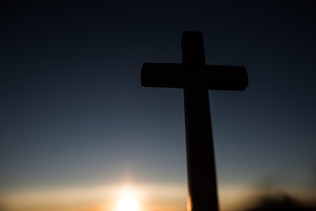 low angle view of silhouette cross against sky during sunset