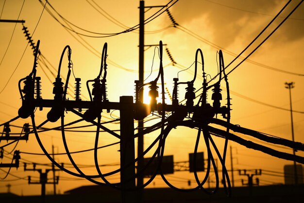 Low angle view of silhouette electricity pylon against sky during sunset