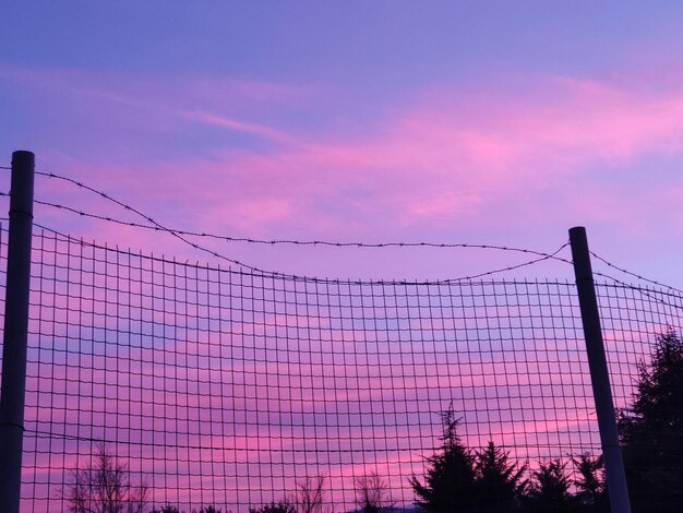 Photo low angle view of silhouette fence against sky during sunset