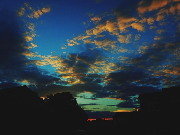 Low angle view of silhouette houses against sky during sunset