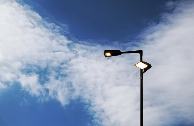 Low angle view of silhouette illuminated street light against sky