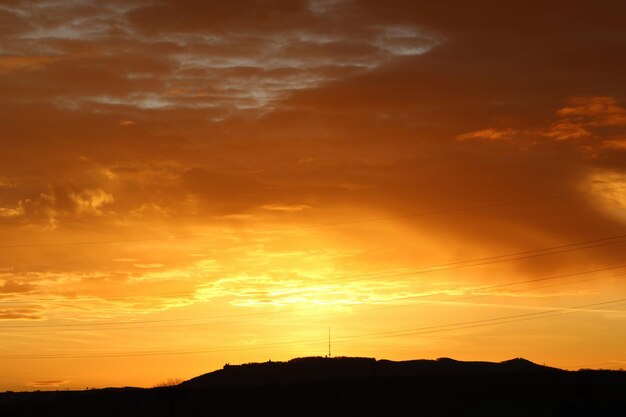 Low angle view of silhouette mountain against dramatic sky