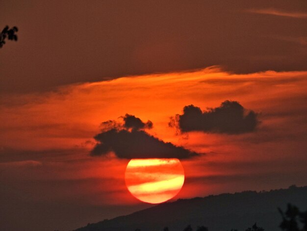 Low angle view of silhouette mountain against orange sky