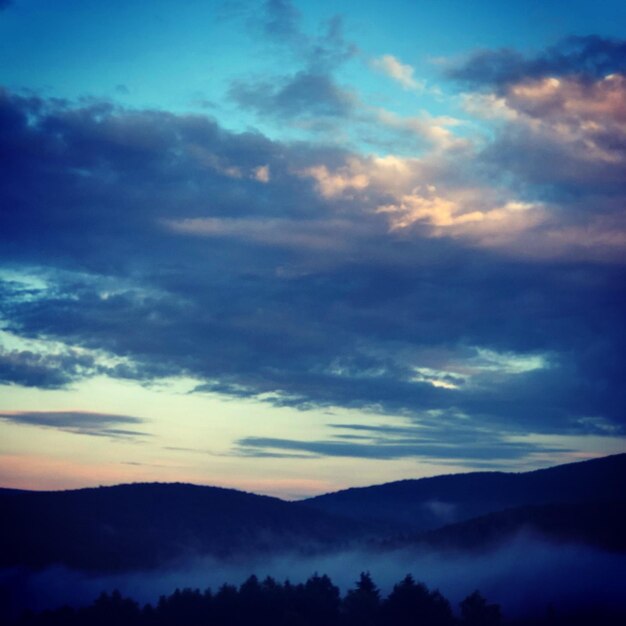 Low angle view of silhouette mountains against dramatic sky