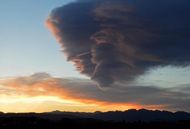 Low angle view of silhouette mountains against dramatic sky