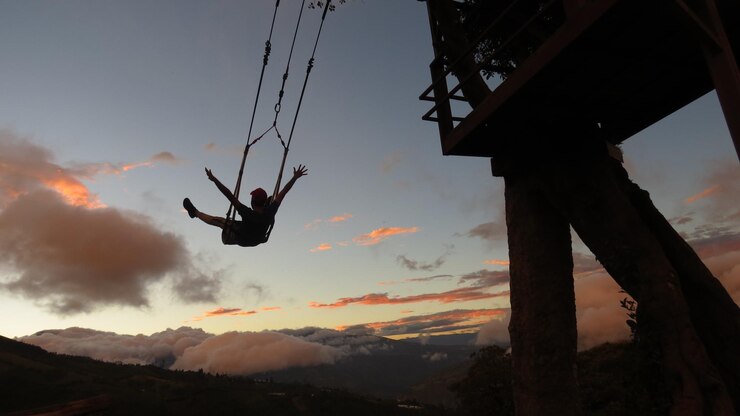 Photo low angle view of silhouette person paragliding against sky during sunset