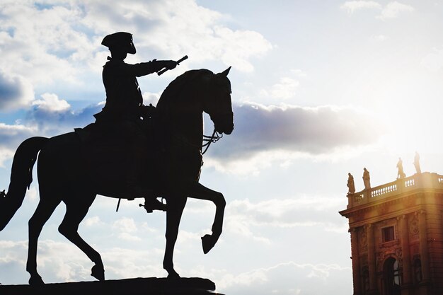 Foto vista a basso angolo della scultura a silhouette contro un cielo nuvoloso