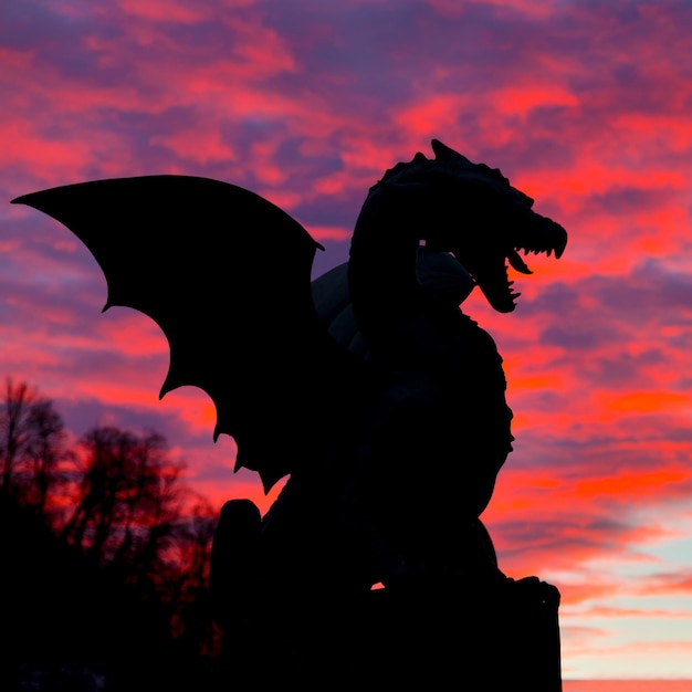 low angle view of silhouette statue against orange sky