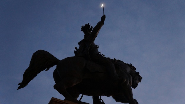 Low angle view of silhouette statue against sky