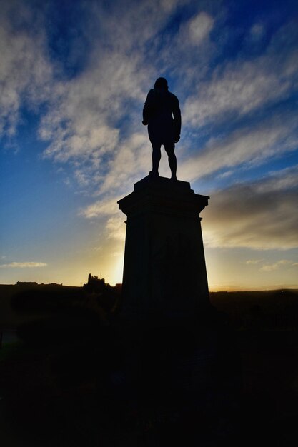 Low angle view of silhouette statue against sky