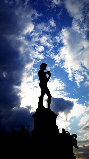 Low angle view of silhouette statue against sky