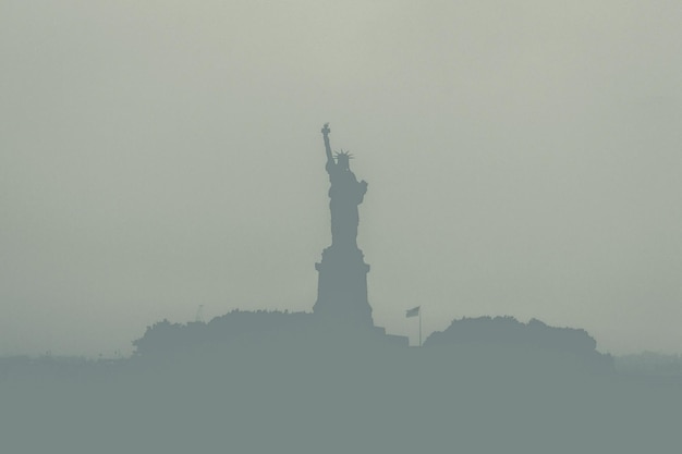 Photo low angle view of silhouette statue of liberty at dusk against sky