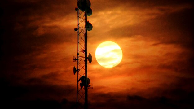 Low angle view of silhouette street light against dramatic sky during sunset