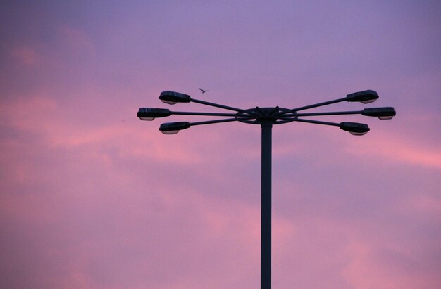 Low angle view of silhouette street lights against sky during sunset