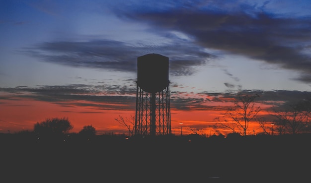 Photo low angle view of silhouette water tower against sky during sunset