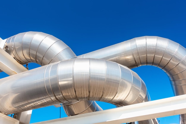 low angle view of silver pipeline against clear blue sky