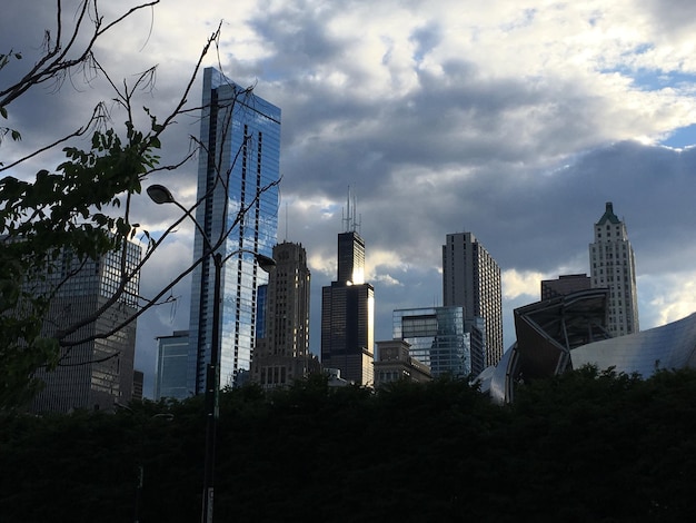 Low angle view of skyscrapers against cloudy sky