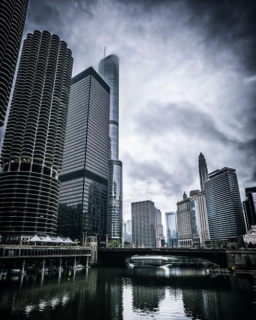 Photo low angle view of skyscrapers against cloudy sky