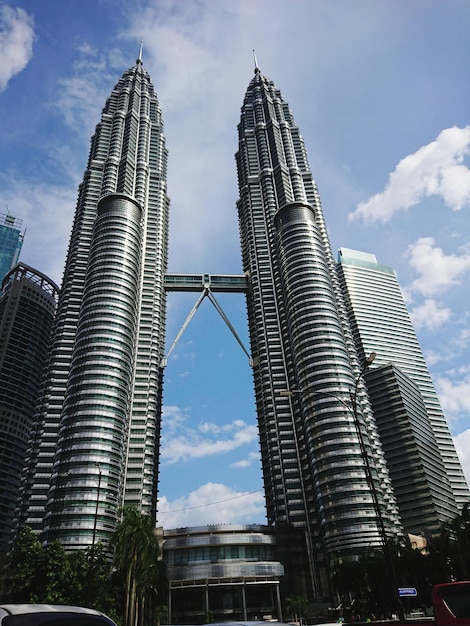 Photo low angle view of skyscrapers against cloudy sky