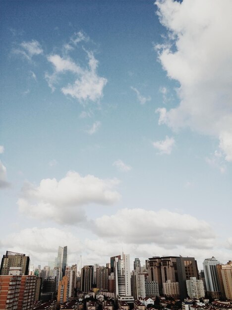 Photo low angle view of skyscrapers against cloudy sky