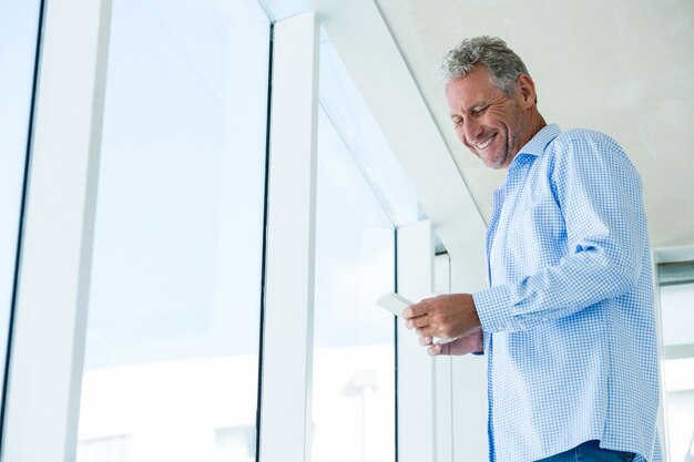 Low angle view of smiling man using phone