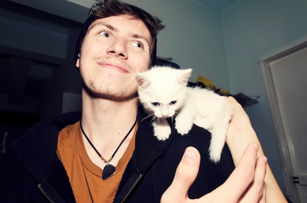 Low angle view of smiling young man with cat at home