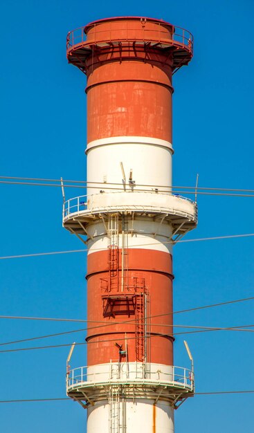 Low angle view of smoke stack against blue sky