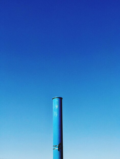 Low angle view of smoke stack against blue sky